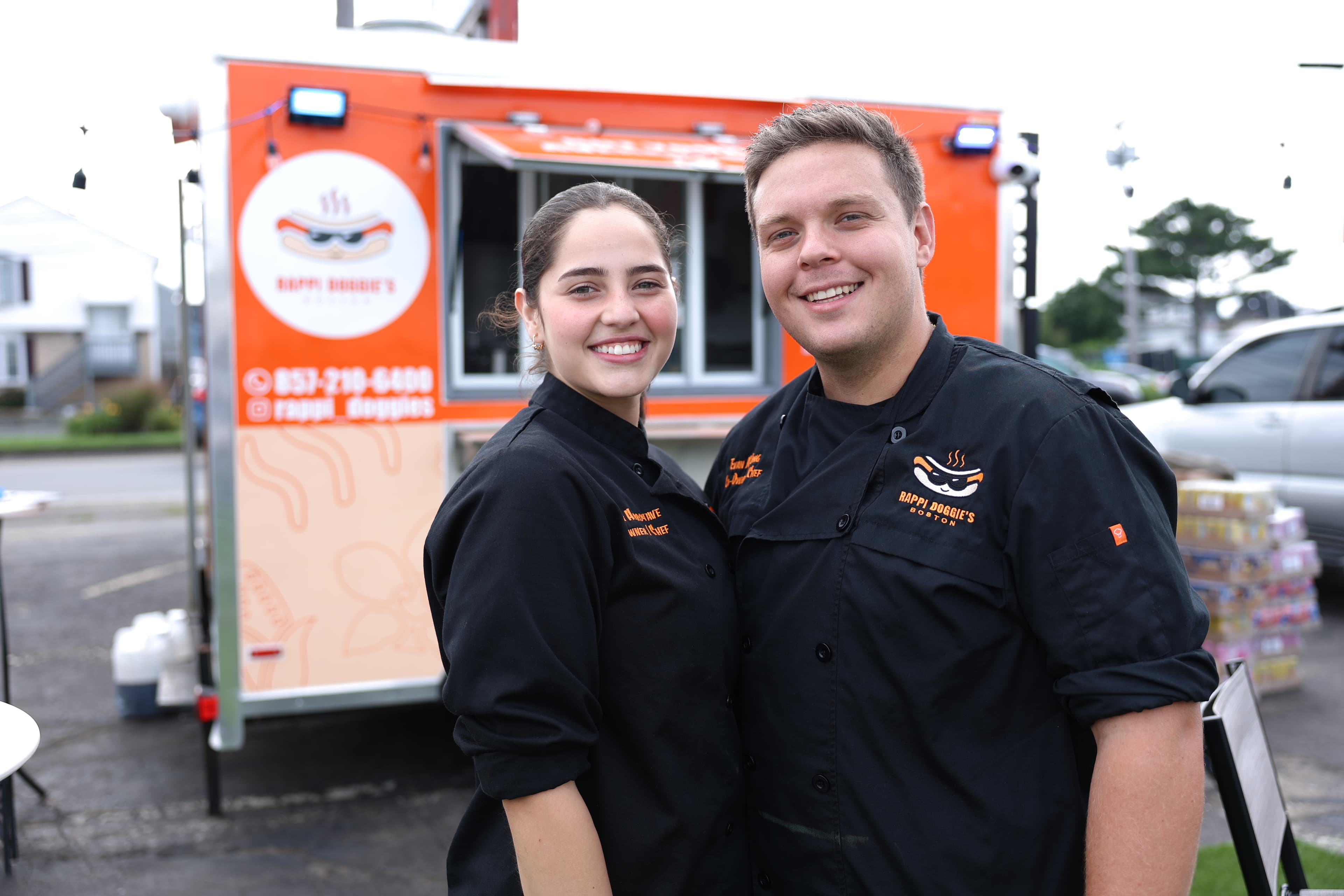 Evan and Angelli standing together in front of the Rappi Doggie's food truck